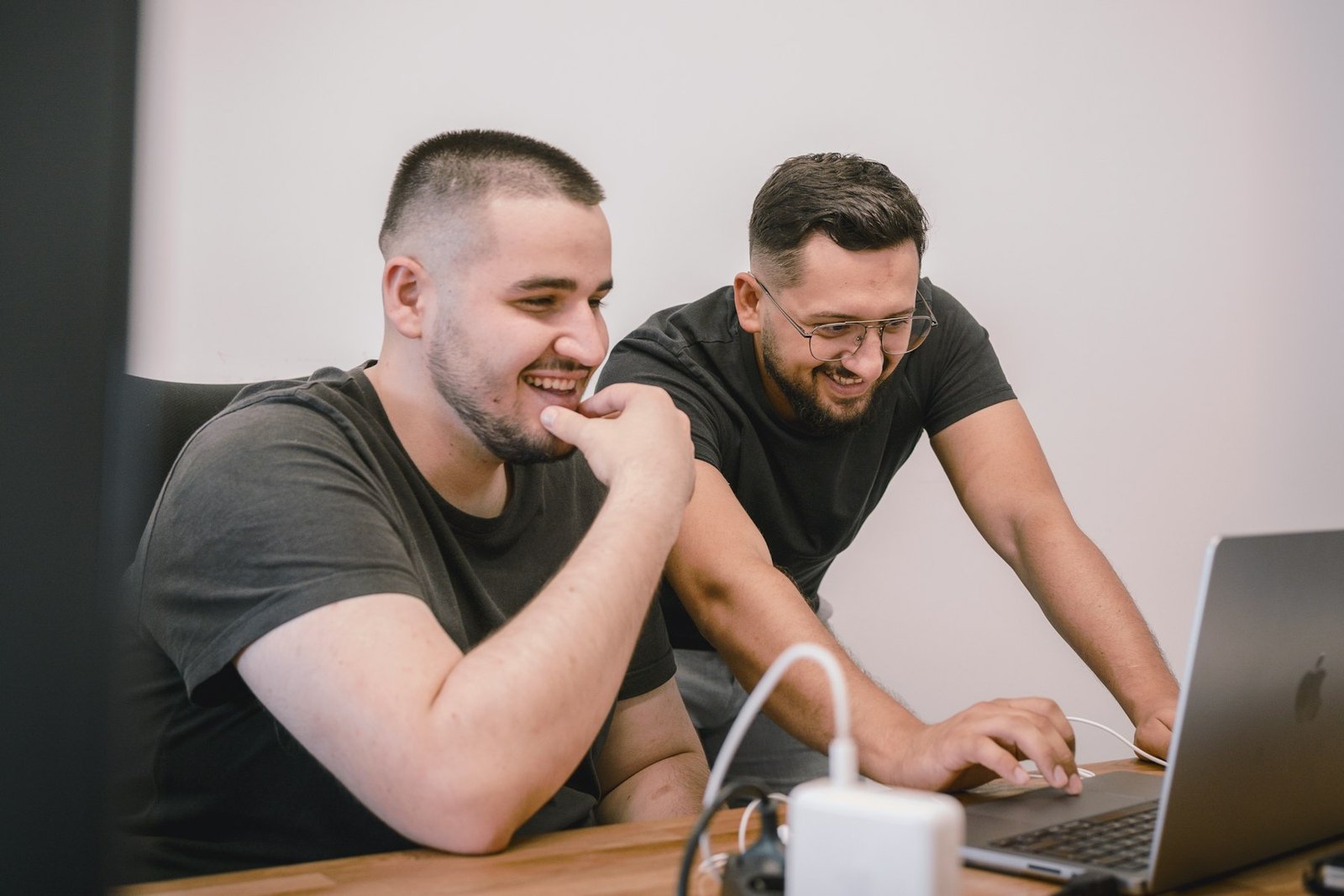 Smiling co-workers collaborating at a desk in a bright office