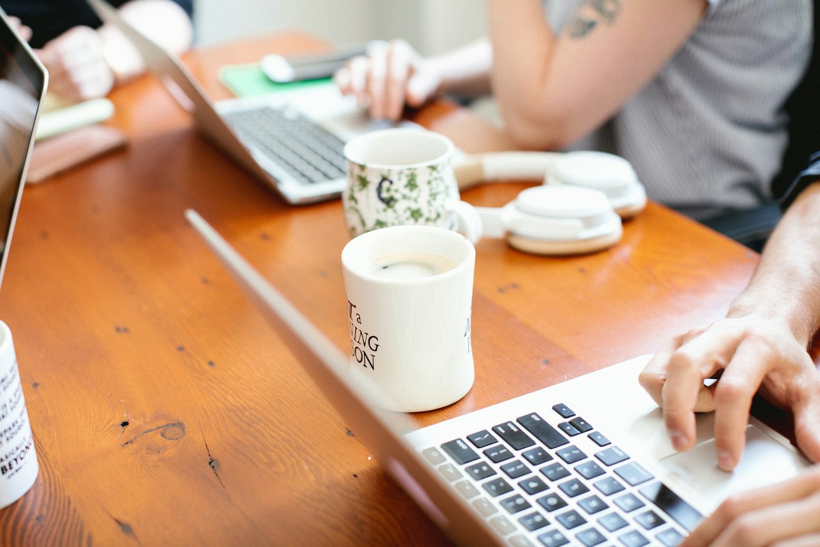 Small team in a meeting with laptops and coffee
